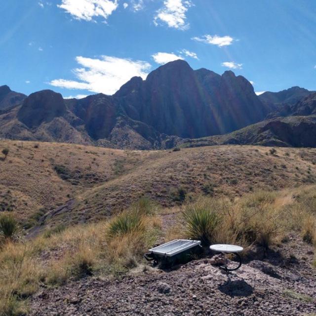 Hydrology sensor in the ground with mountains in the background